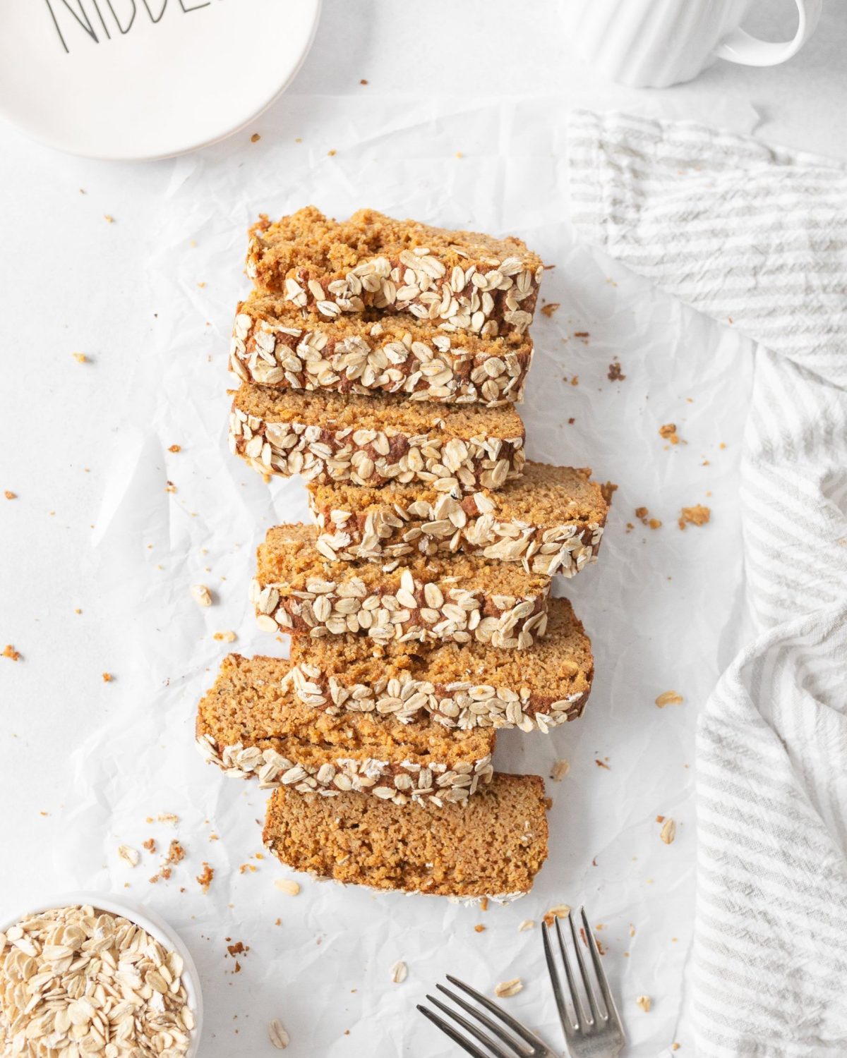 Gf Pumpkin Bread with Hemp and Oats sliced on parchment paper.