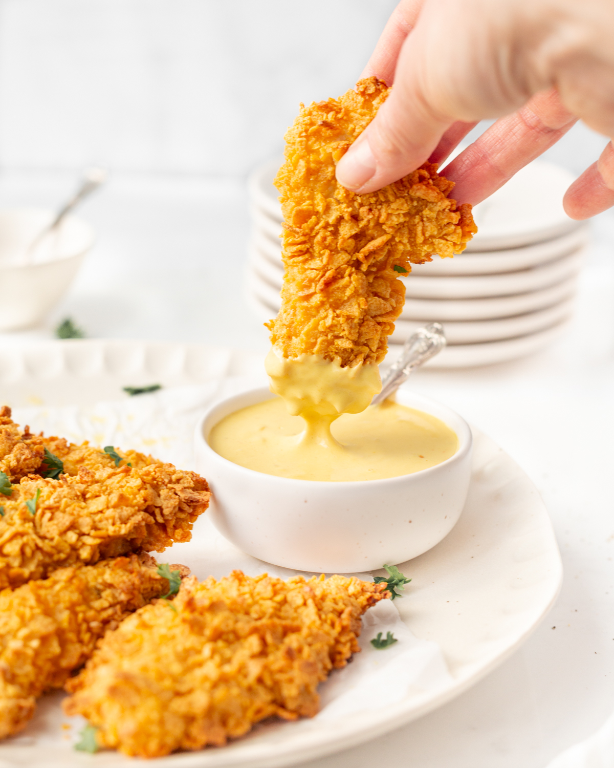 Cornflake crusted chicken tenders baked and dipped into creamy honey mustard sauce.