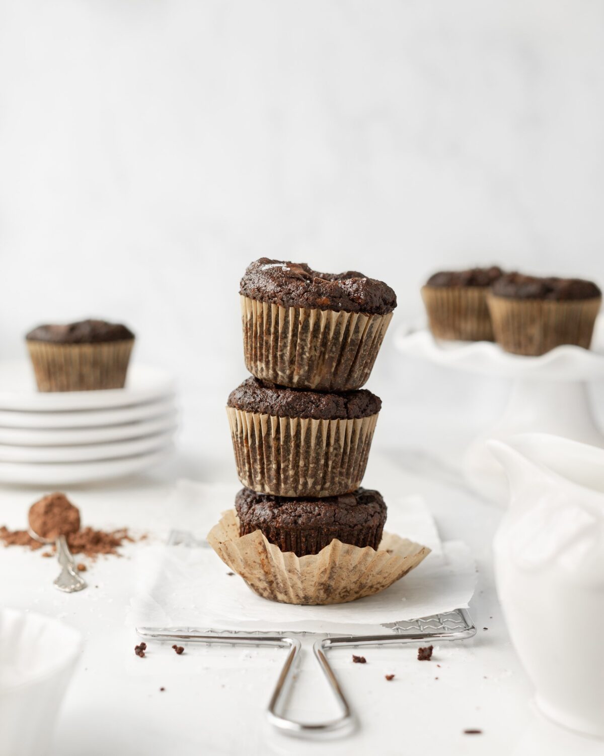 3 Triple Chocolate GF Banana Protein Muffins stacked on parchment paper.