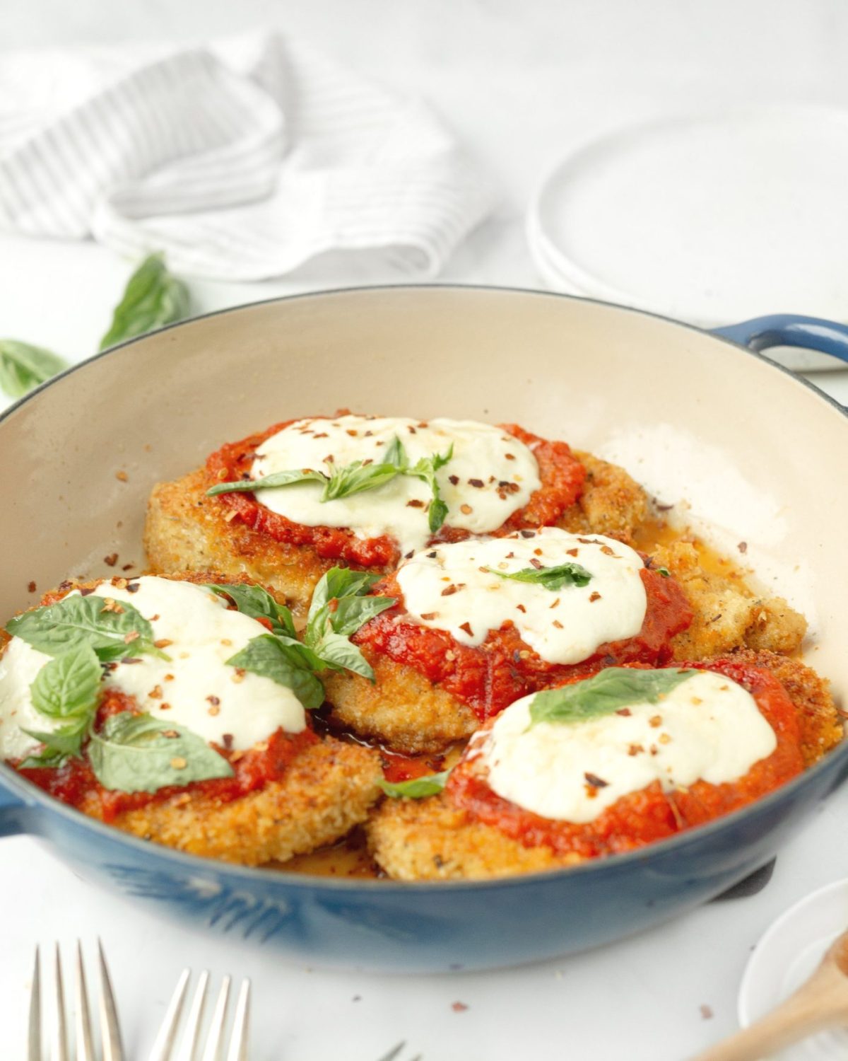 Chicken Parmigiana with Burrata and Honey in a blue enamelled skillet.