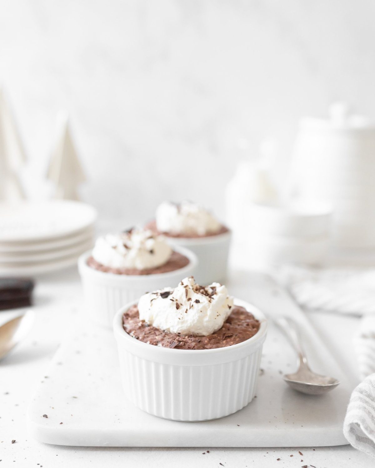 Mexican Chocolate Chia Pudding in small ramekins topped with whipped cream and chocolate shavings.