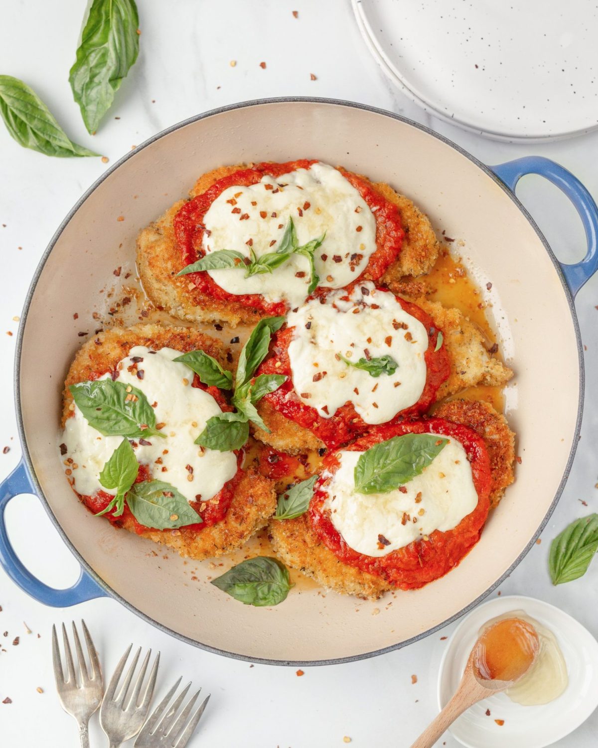 Chicken Parmigiana with Burrata and Honey in a skillet (top down)
