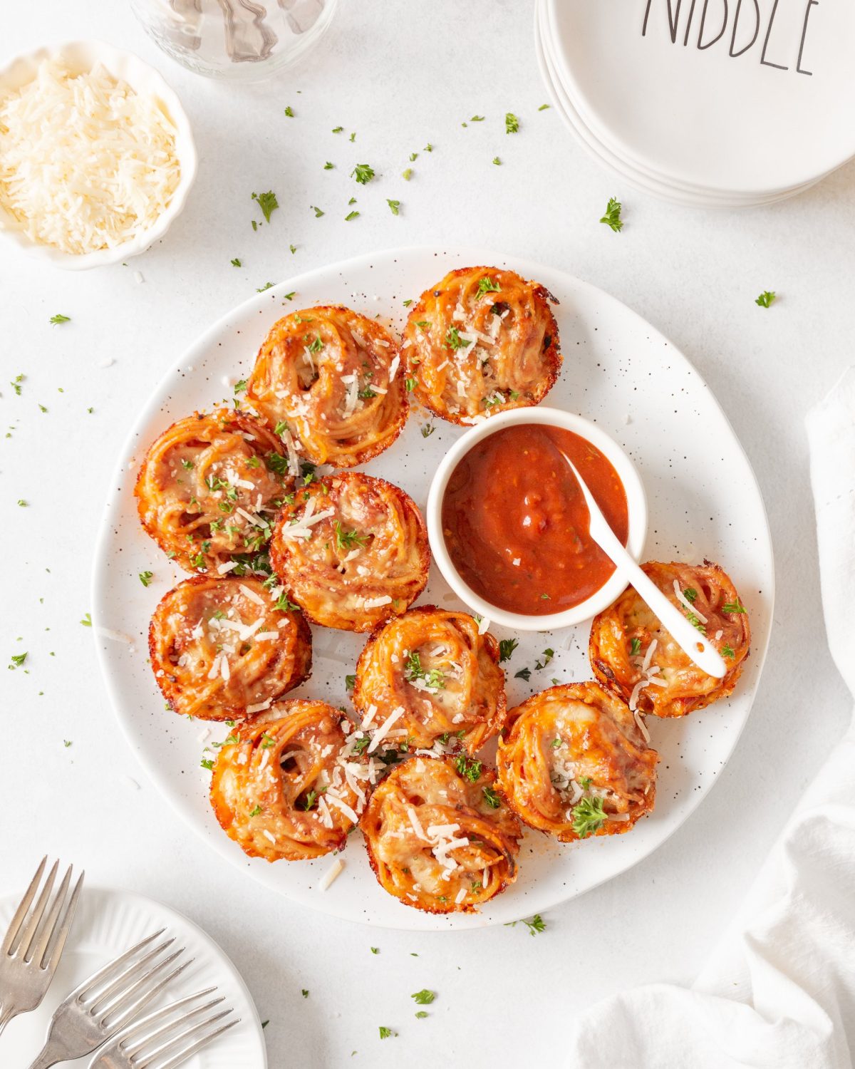 Cheesy Baked Spaghetti Bites plated with marinara sauce.