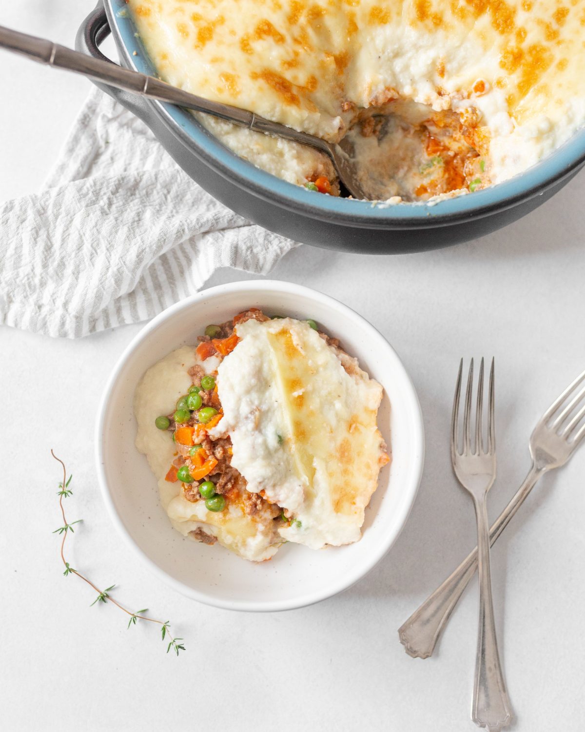Shepherd's Pie with Cauliflower Mash portioned out into a bowl with two forks beside it.