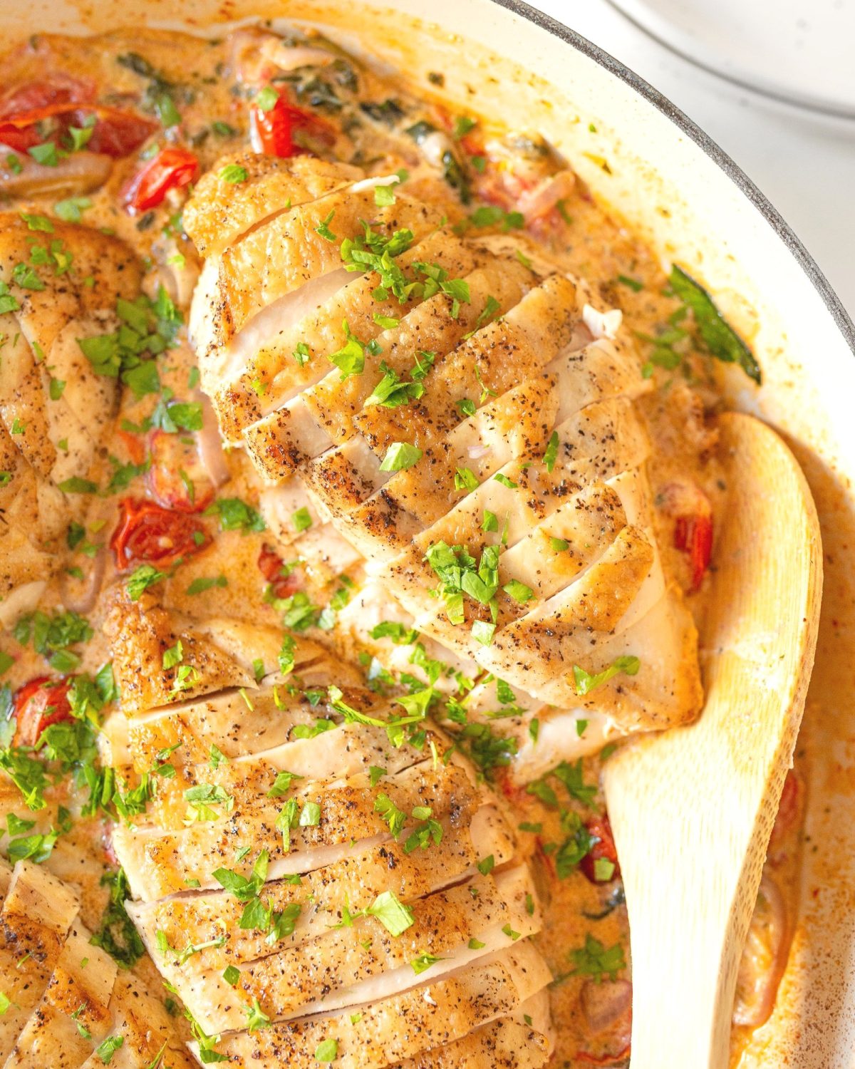 Baked Boursin Chicken with Spinach and Tomatoes baked in a skillet.