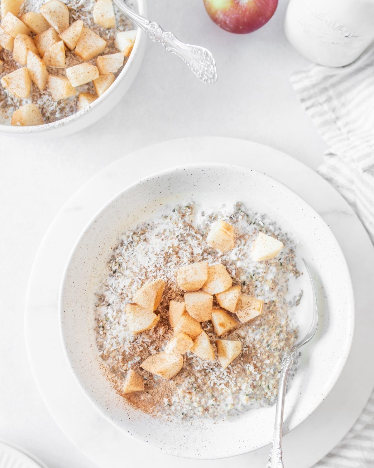 Low-carb Apple Cinnamon Seed "Oatmeal" served in a bowl and topped with fresh apples.