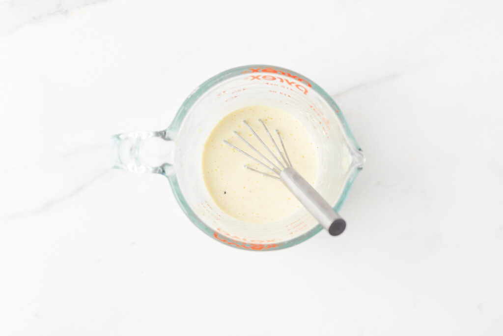 Process shot #3: Lemon aioli whisked together in a glass measuring cup.
