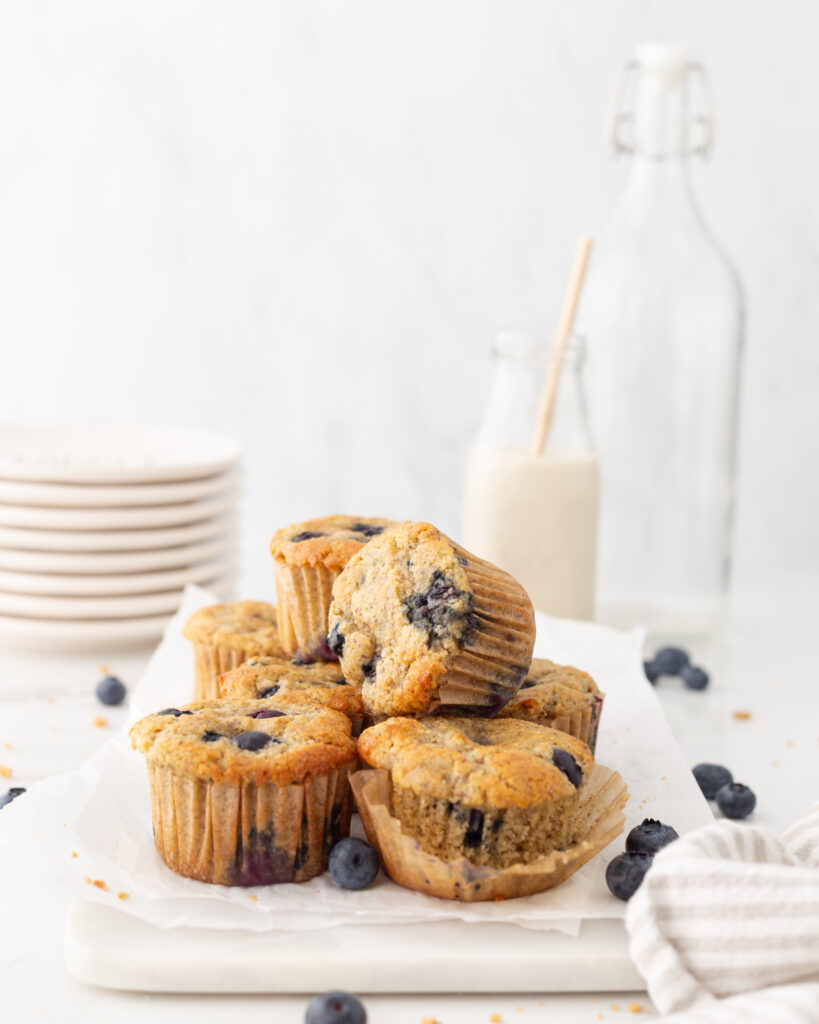 Almond Flour Blueberry Muffins on parchment paper on a marble serving board. 