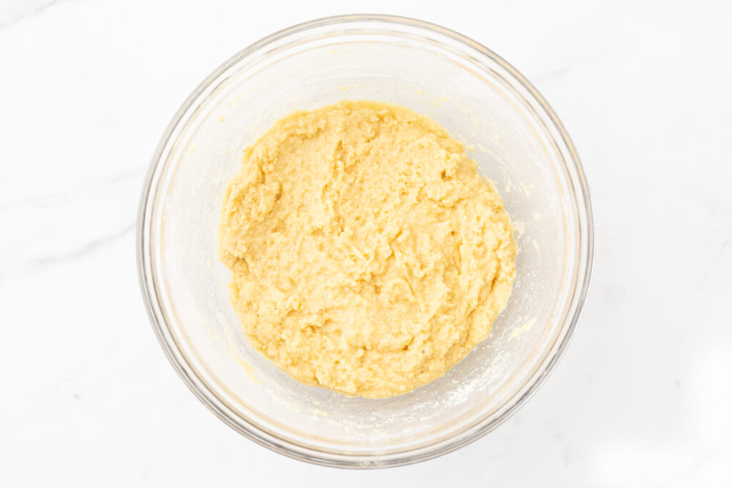 Process shot #2: Ingredients for gluten-free biscuit cobbler topping mixed together in a glass mixing bowl. 